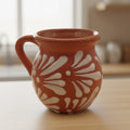 Handmade Mexican brown Talavera mug with intricate patterns, crafted from clay, displayed on a neutral background.