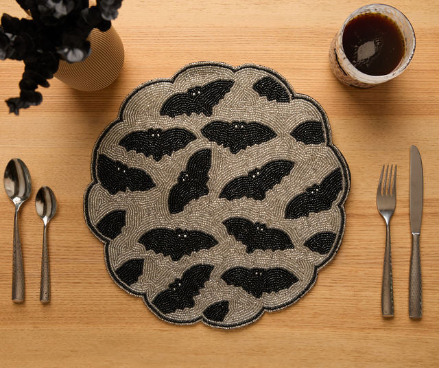Handmade black and gold Halloween bat beaded placemat with scalloped edges for gothic table decor and spooky party settings.