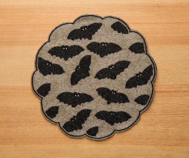 Handmade Halloween bat beaded placemat with black and gold scalloped edges, gothic table decor for spooky party settings.