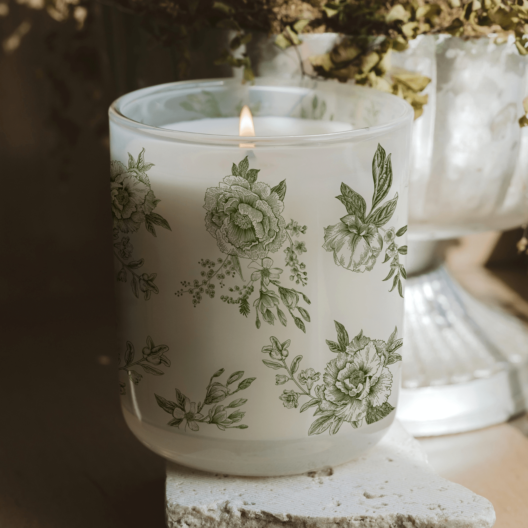 Green floral soy candle by Sweet Water Decor with lavender and sage scent, featuring a decorative floral pattern.