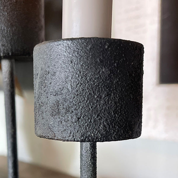 Distressed black metal candle holder with rustic design, perfect for home decor and setting a cozy ambiance.