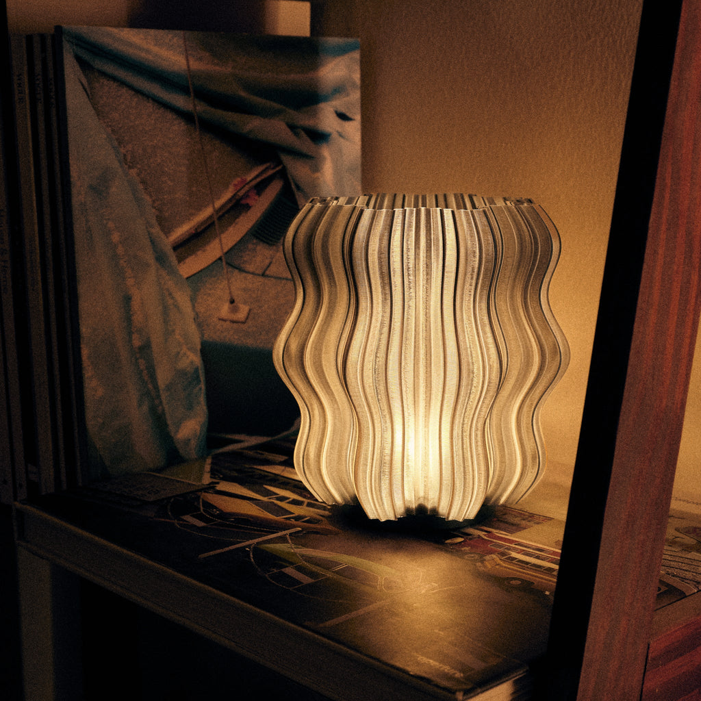 Wooj Design Mini Wavy Lamp with a sleek, cordless smoke-colored wavy design, displayed on a modern lifestyle setting.