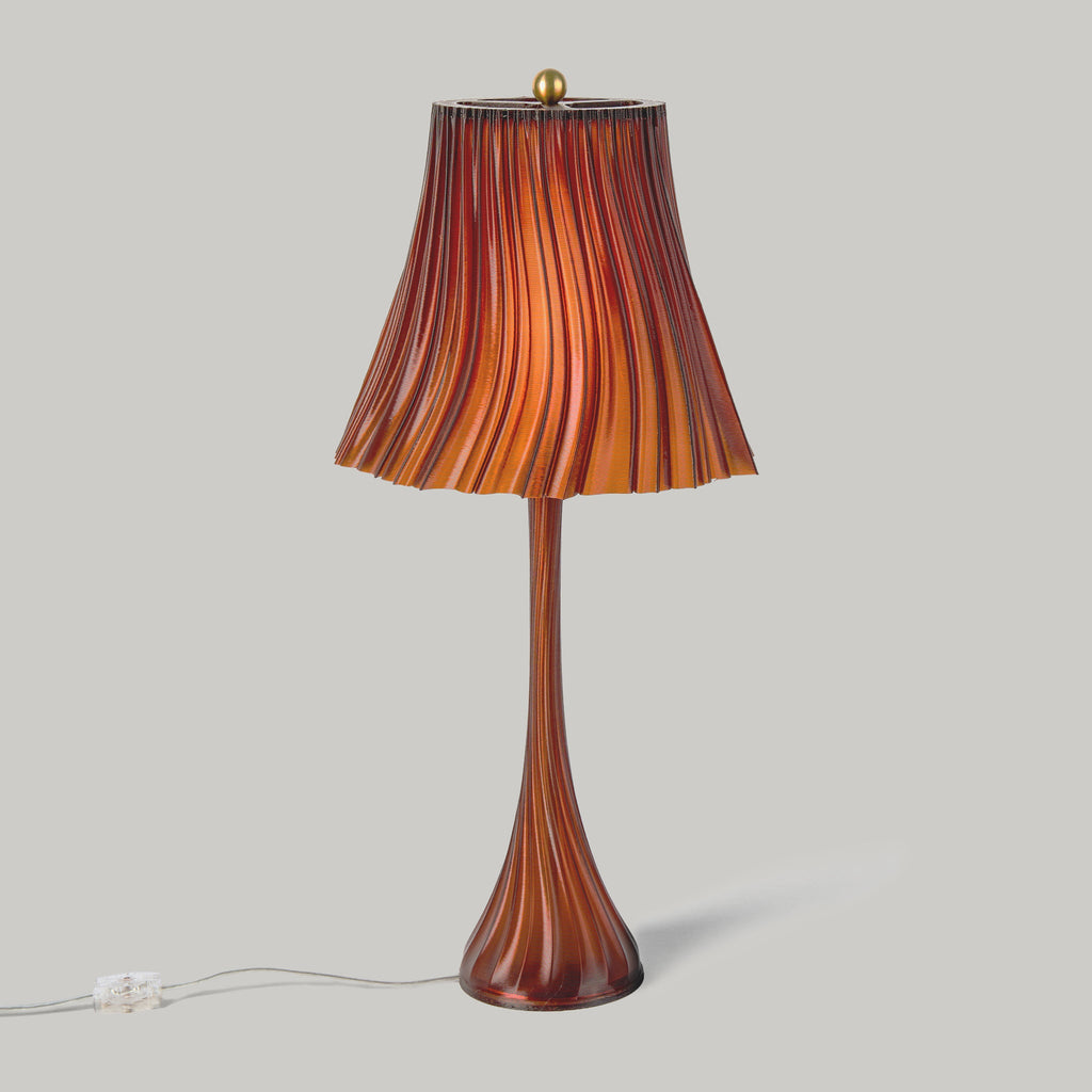 Wooj Design Pleat Lamp with a sleek, amber-colored pleated lampshade illuminating a modern interior space.