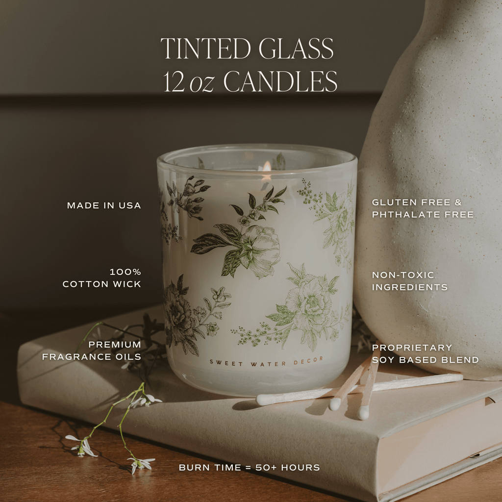 Green floral soy candle in a tinted glass container from Sweet Water Decor, showcasing a serene floral design.