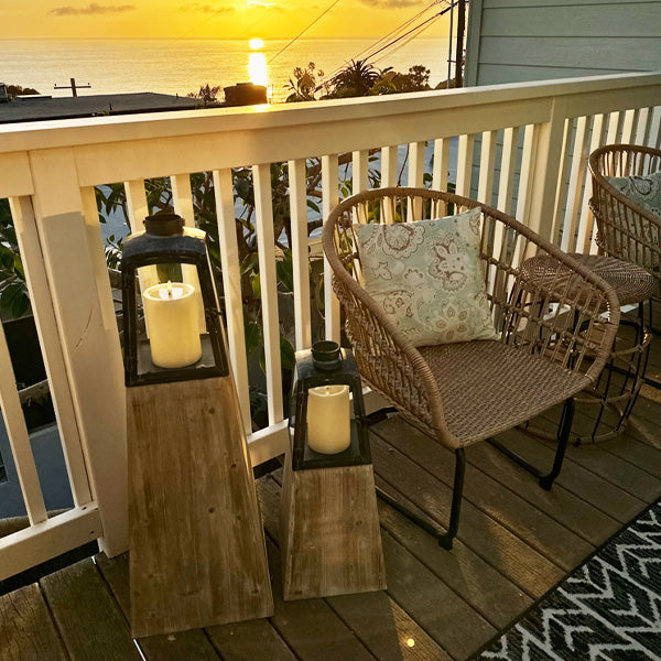 Set of two Decor Steals removable metal lanterns with wood bases, featuring glass panels and handle for decorative lighting.