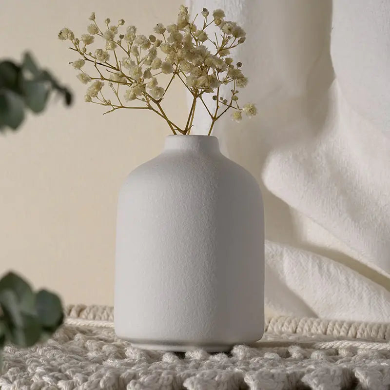 Simple ceramic vase with a smooth white finish, ideal for floral arrangements or decorative display.