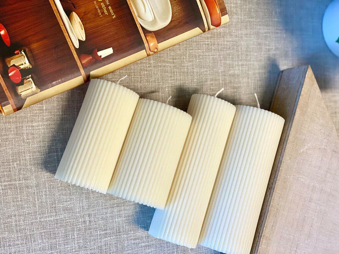 Minimalist white ribbed pillar candle from Crazy About Candles, showcasing textured design and smooth finish.