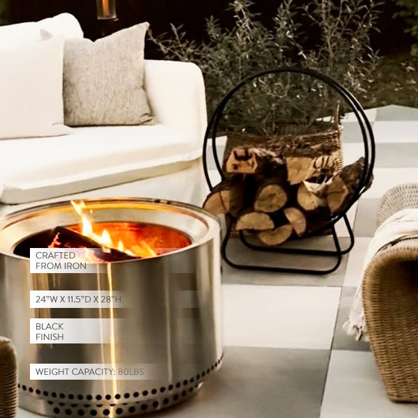 Decor Steals black iron loop fireplace log holder with curved design holding firewood in a cozy living space.
