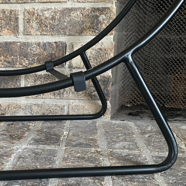 Decor Steals black iron loop fireplace log holder with curved design holding firewood in a cozy living space