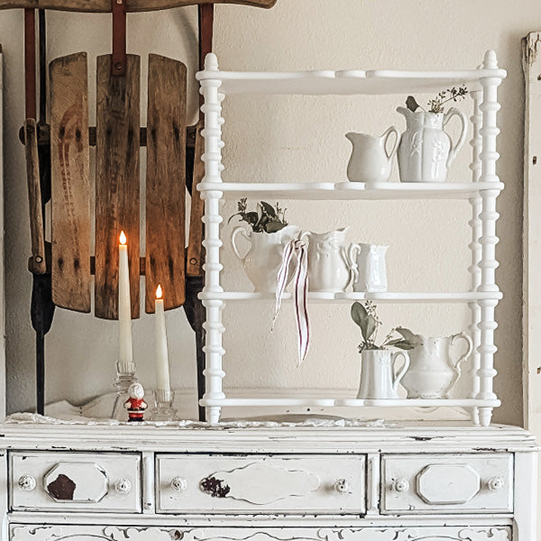 White spindle wood shelf from Decor Steals, featuring a classic spindle design, mounted on a wall with visible brackets.